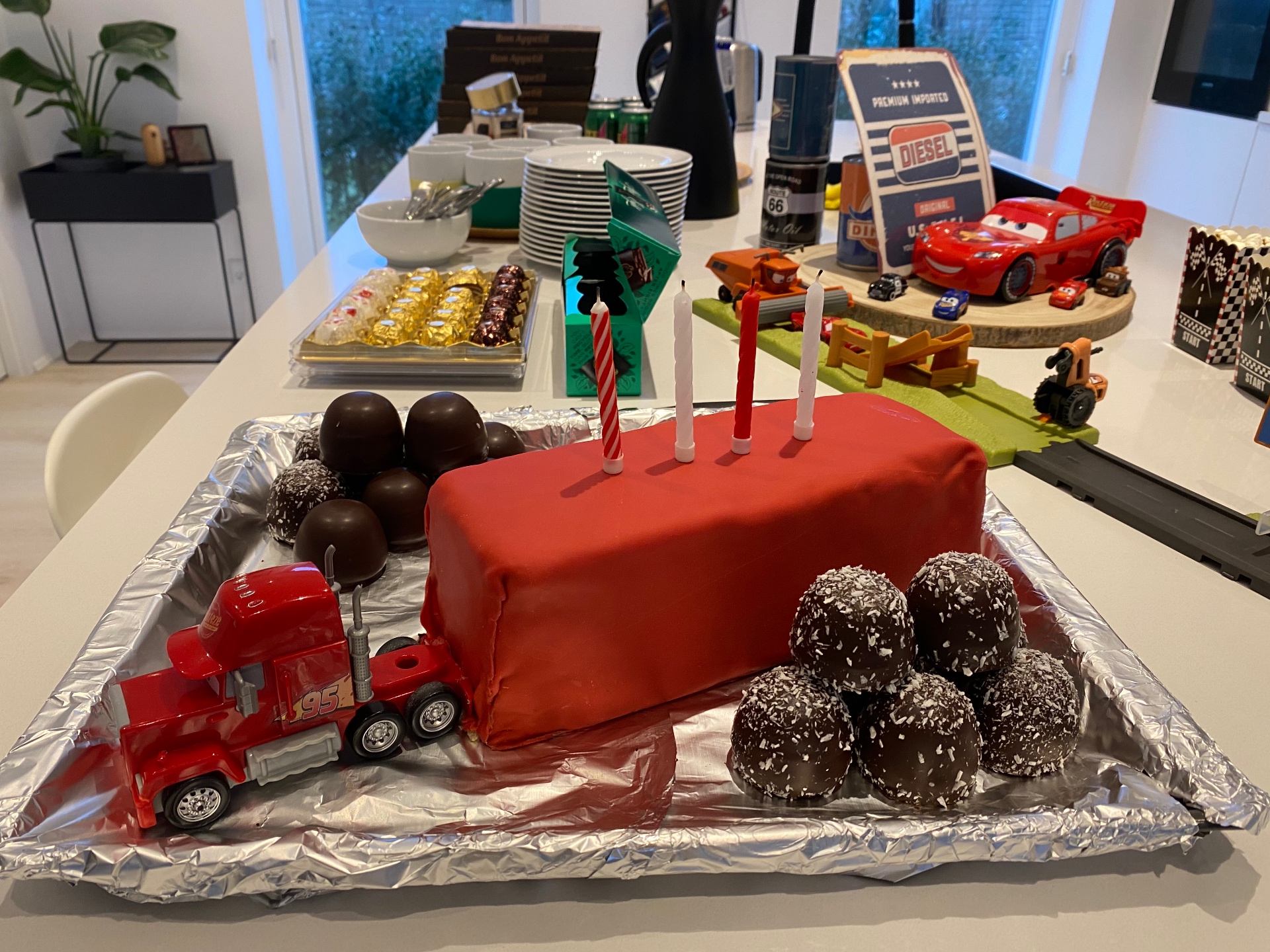 Homemade red Mack truck birthday cake with a toy truck cab